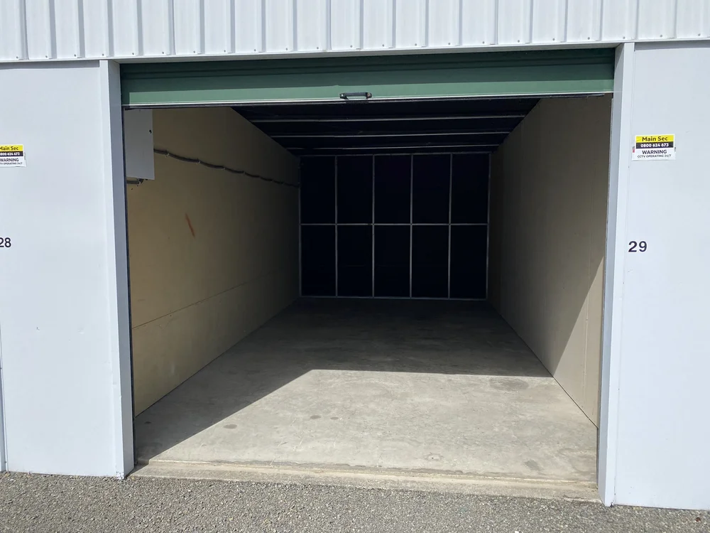 An open storage unit door showing the unit number and 24/7 CCTV monitoring signage